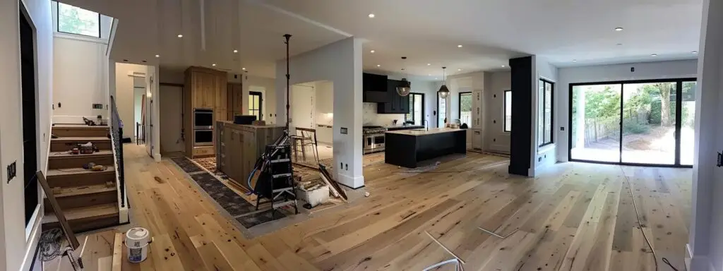 an elegantly designed interior showcases freshly installed hardwood flooring, with expert installers meticulously aligning the planks in a modern living room, highlighting the transformation and precision that professional service provides.