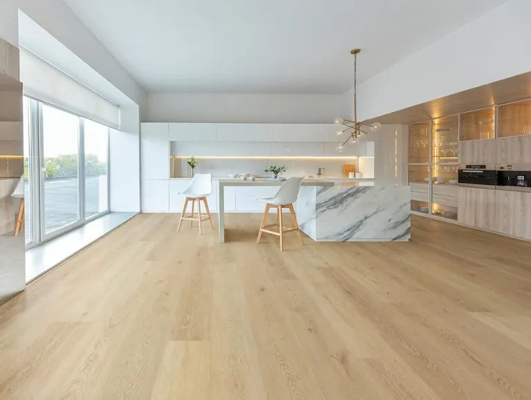 Modern kitchen interior featuring Royal 5mm Vinyl Plank flooring in 'Desert' color, complemented by white cabinetry and marble accents.