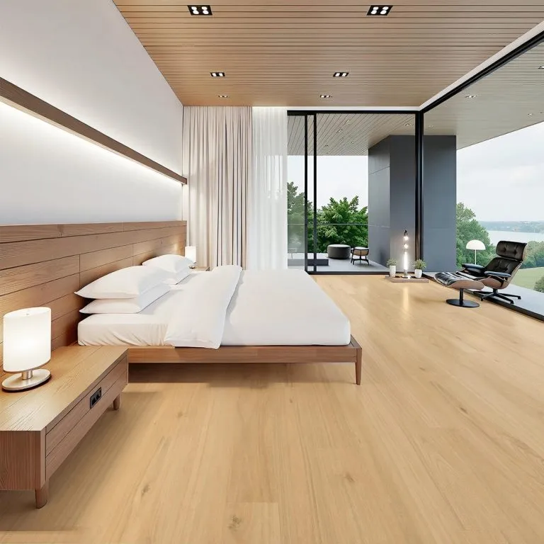 Modern bedroom featuring Royal Floors 10mm Extreme hybrid flooring in a light wood finish, complemented by a wooden bed frame, bedside lamp, and large windows showcasing a scenic view.