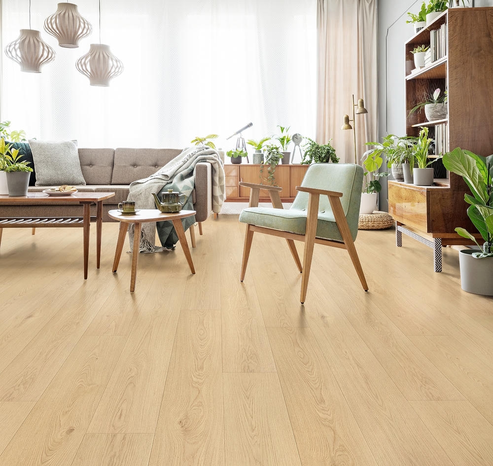Bright living room featuring RoyalStep 12mm laminate flooring in Native Oak, with modern furniture, plants, and natural light.