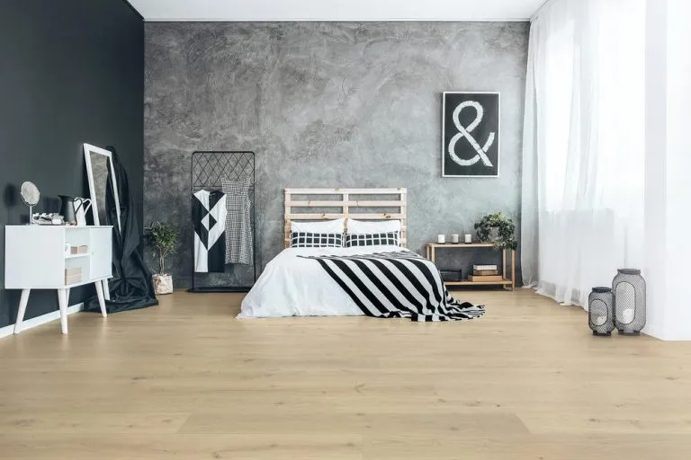 Modern bedroom featuring Royal 15/4mm Oak flooring in Linen color, minimalist decor, bed with striped bedding, and stylish furnishings.