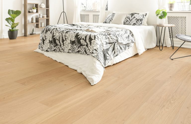 Royal 14/2mm Oak timber flooring in a modern bedroom setting, featuring light wood tones and natural grain patterns.