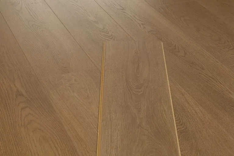 Warm Oak laminate flooring planks showcasing realistic wood grain texture in a modern interior setting.