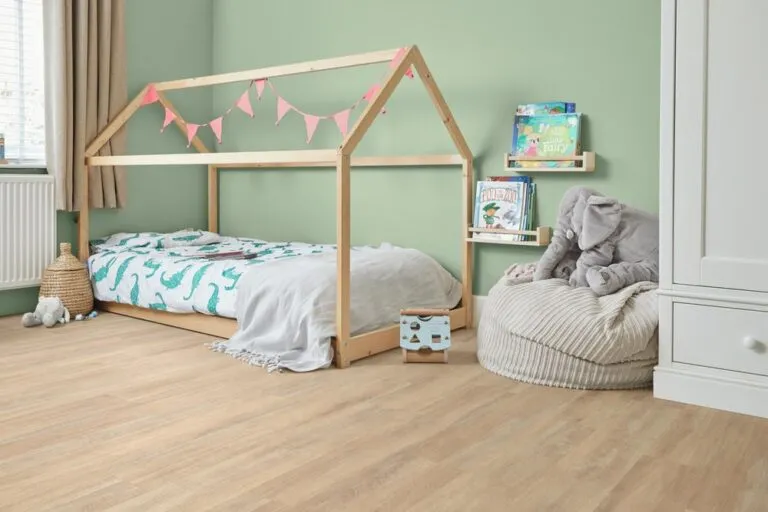 Child's bedroom featuring Hamden luxury vinyl flooring by Karndean, wooden bed frame with playful decor, soft toys, and books on display.