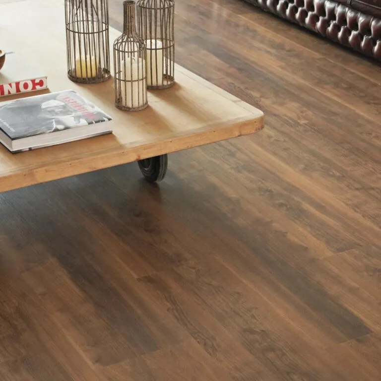 Luxury vinyl flooring featuring Heritage Oak design, showcasing a wooden coffee table with decorative lanterns and candles, set in a stylish living room environment.
