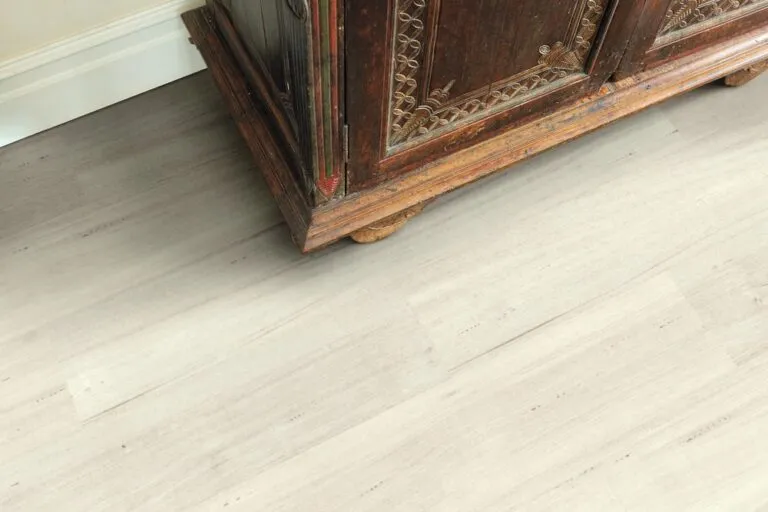Bleached Tasmanian Oak Loose Lay Longboard vinyl flooring beneath an ornate wooden cabinet, showcasing a modern, spacious interior design.