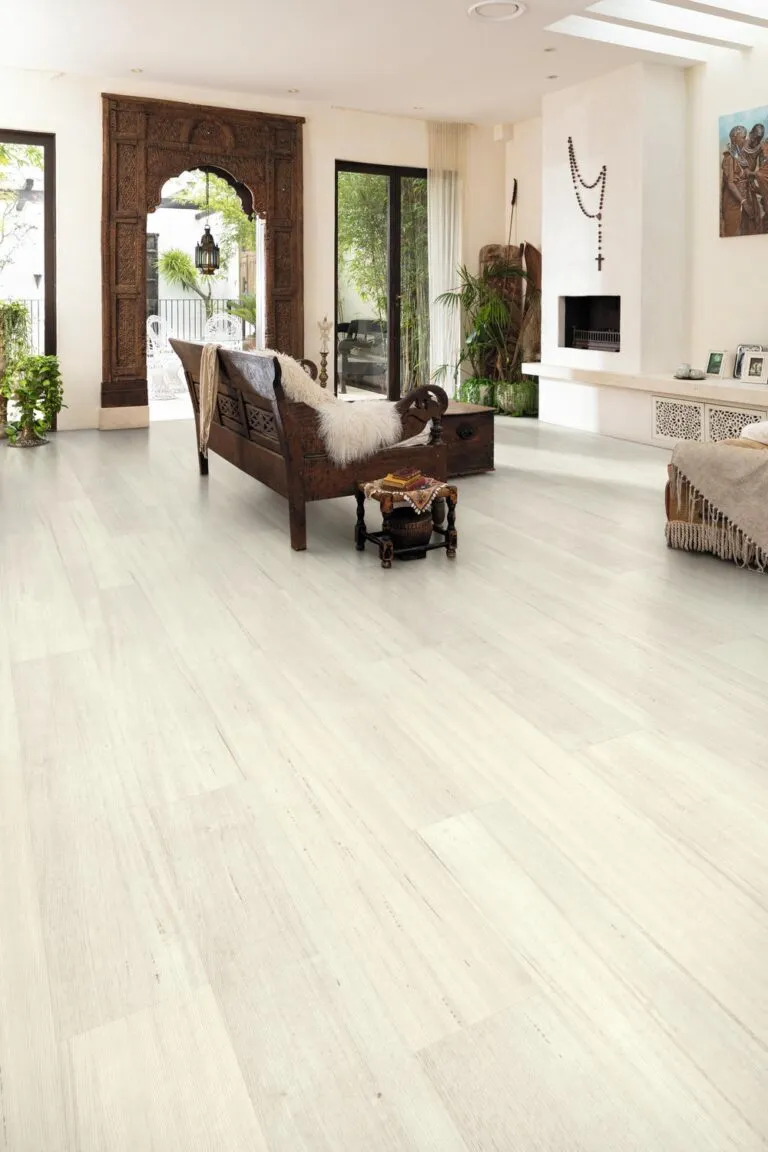 Living room featuring Loose Lay Longboard vinyl flooring in Bleached Tasmanian Oak, showcasing a spacious design with natural timber appearance, complemented by wooden furniture and greenery.