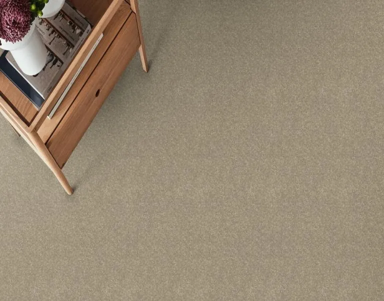 Mushroom Stipple carpet in a cozy interior setting, showcasing a soft, neutral texture and color, complementing wooden furniture.